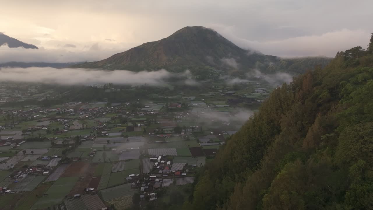 Bình minh rực rỡ trên núi lửa Batur, những thửa ruộng bậc thang và hồ nước với mây, Indonesia