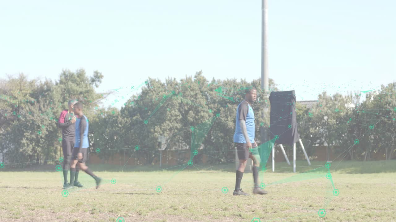Soccer referee raising arm signaling foul while red players stepping aside and blue team restarting