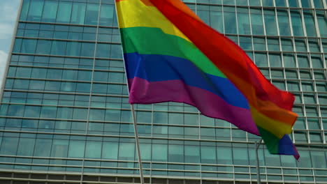 banderas del arco iris contra el rascacielos de vidrio en el centro de varsovia marcha del orgullo celebración evento símbolo de los derechos lgbt glbt transgénero amor igualdad