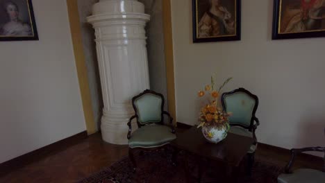 Pan-shot-of-high-end-chairs-and-carpet-at-a-room-in-a-castle-in-Slavkov-u-Brna,-Czech-Republic,-with-paintings-on-the-wall