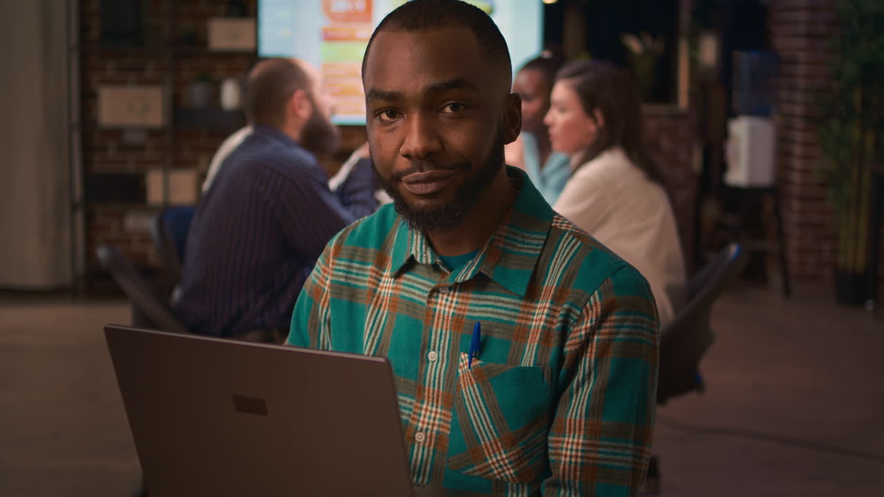 African american smiling employee working on laptop portrait, slowmotion
