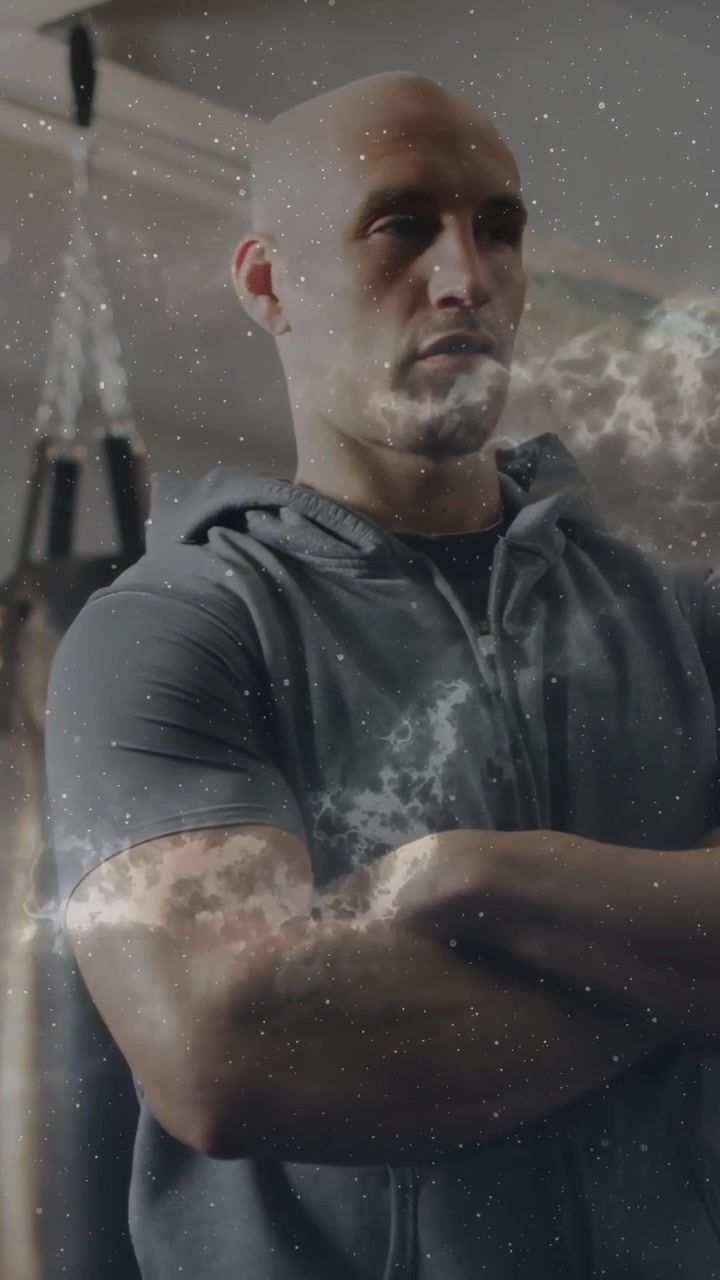 Vertikal video: Mand med krydsede arme i fitnesscenter, kamera zoomer ind, tåge svæver over underarme til fitness.