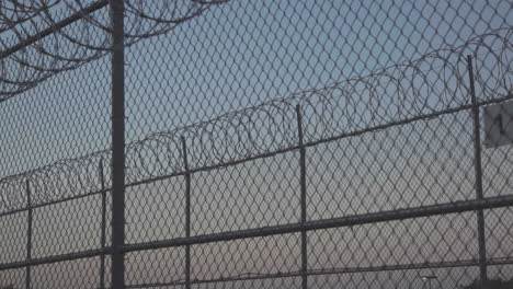 prison fences with razor wire looking through 4k