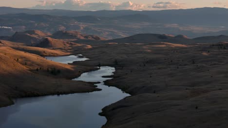 Crepúsculo-Tranquilo:-Panorama-Aéreo-De-Praderas,-Lagos-Y-Colinas-Encantadoras