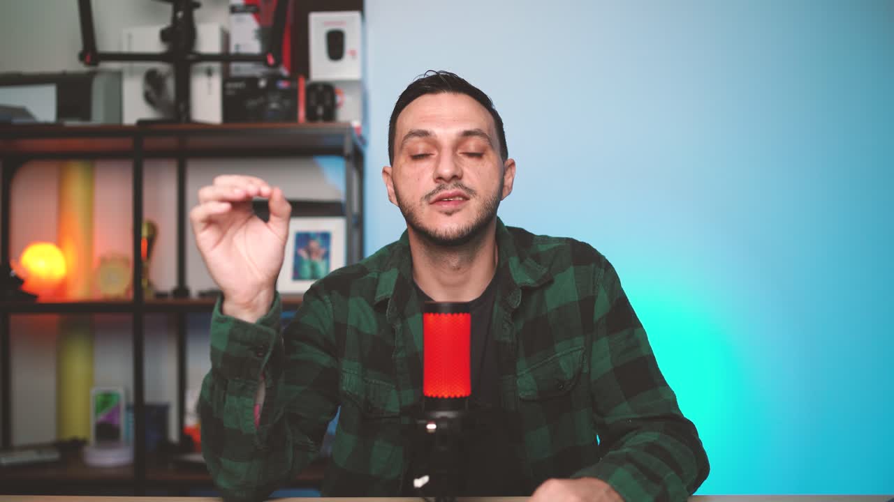 Content creator records podcast content in a cozy and well-lit studio, engaging the camera while talking into a microphone.