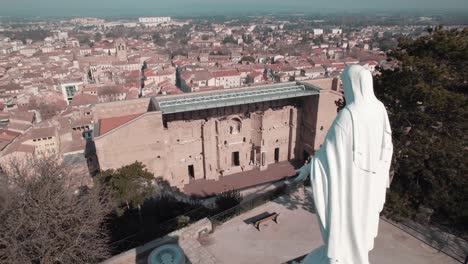 en primer plano la estatua de la virgen maría que vigila la ciudad de orange y su antiguo teatro