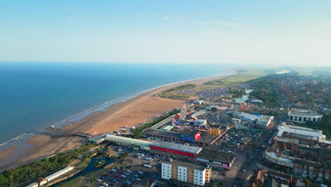 Skegness,-Lincolnshire,-comes-to-life-in-this-aerial-video,-highlighting-its-vibrant-beach-town,-amusements,-iconic-pier,-and-a-summer-evening-vibe