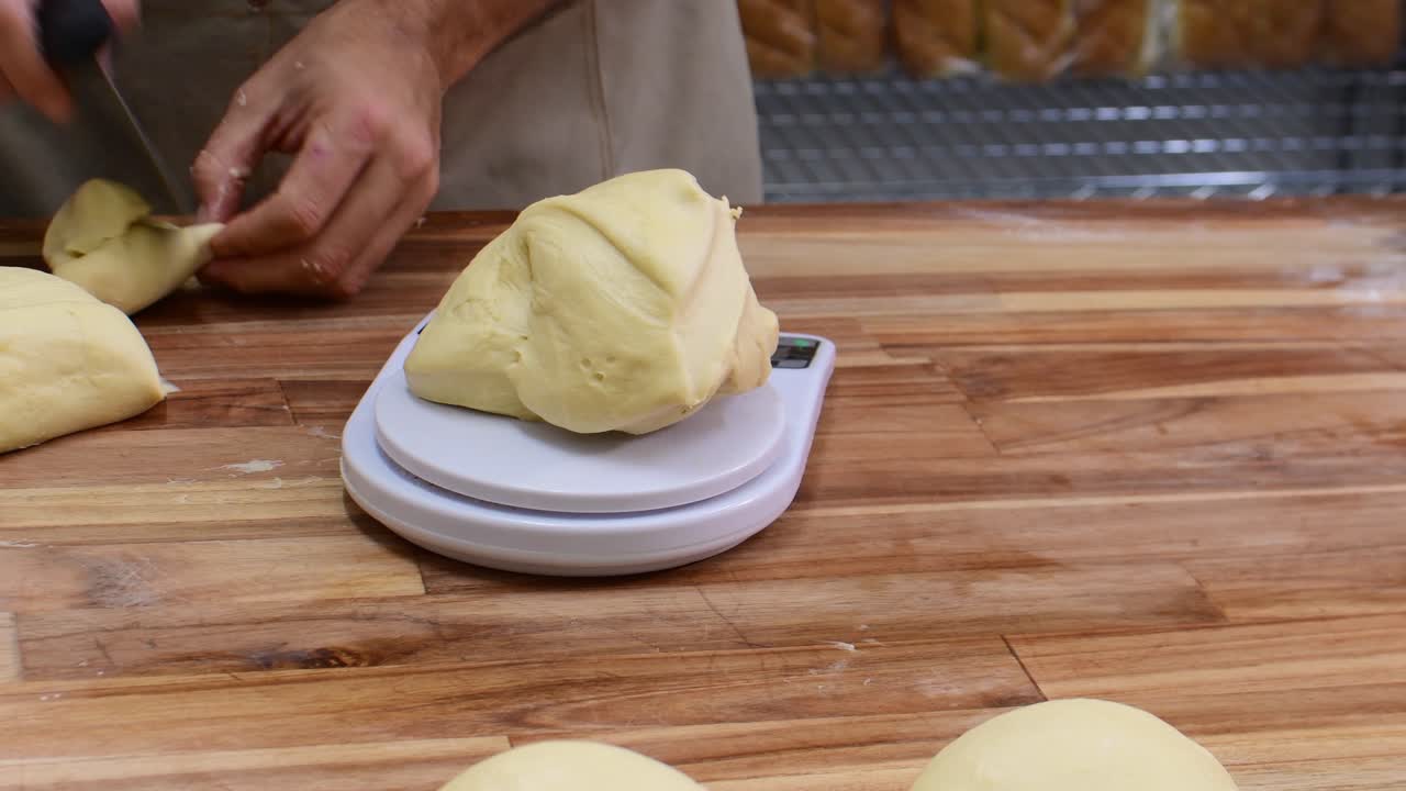 Mão pesando massa em uma balança para assar pão em um ambiente de cozinha aconchegante