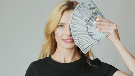 beautiful girl with a lot of dollars in the hands on the white background