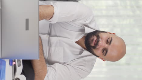 Vertical-video-of-Home-office-worker-man-looking-with-satisfied-expression.