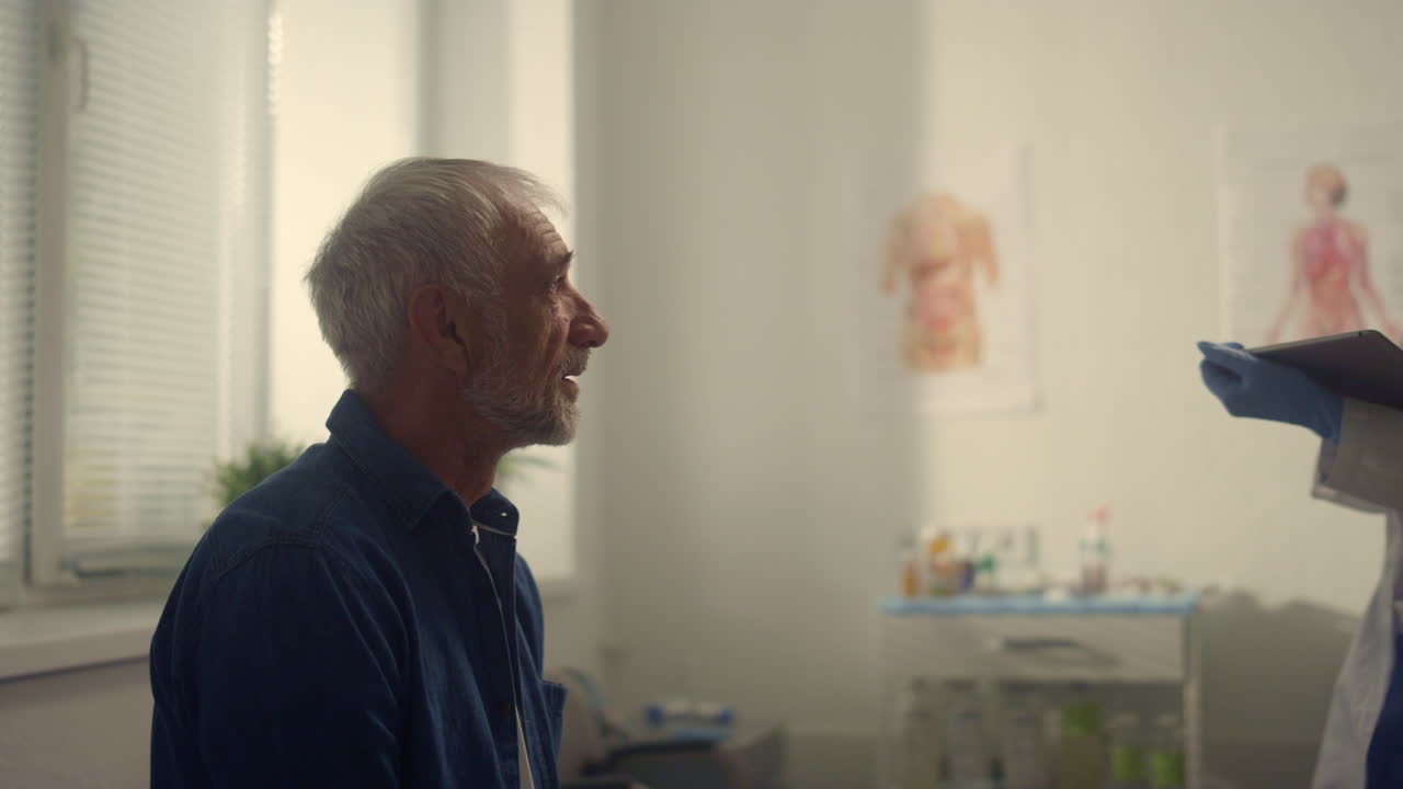 Elderly patient discussing woman doctor health complaints in hospital close up.