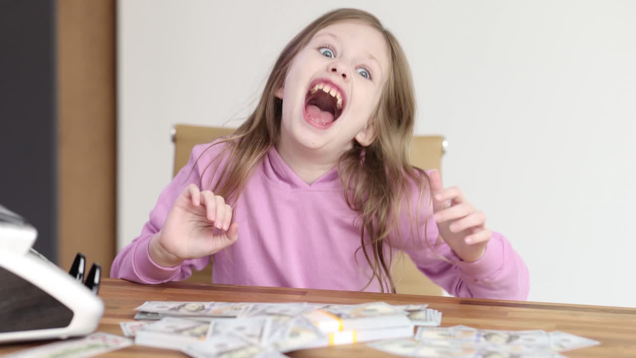 Young girl's shocked and excited reaction to a pile of cash