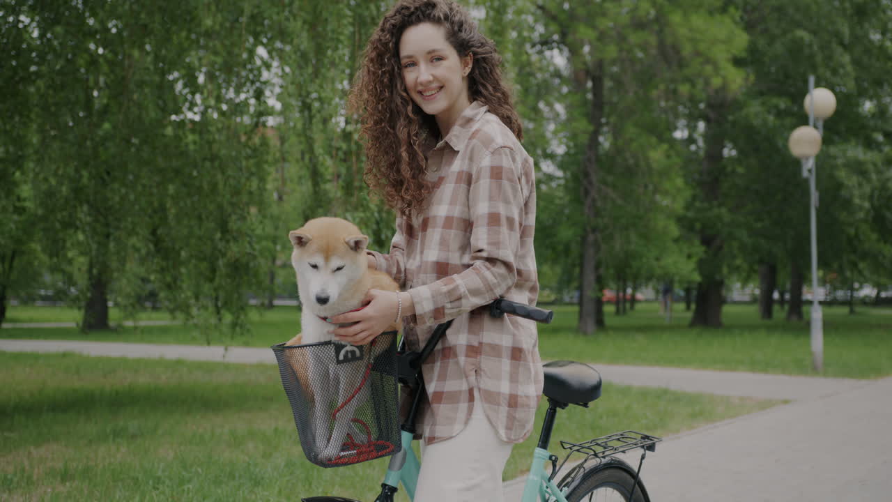 Woman with Dog on a Bicycle in a Park