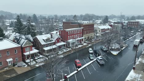 snow flurries over american town square during winter