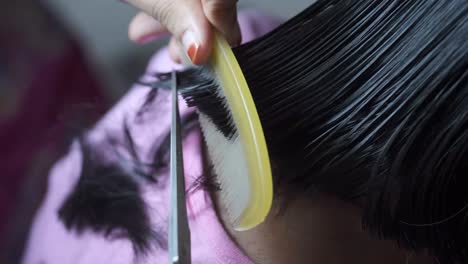 una mujer se corta el cabello.