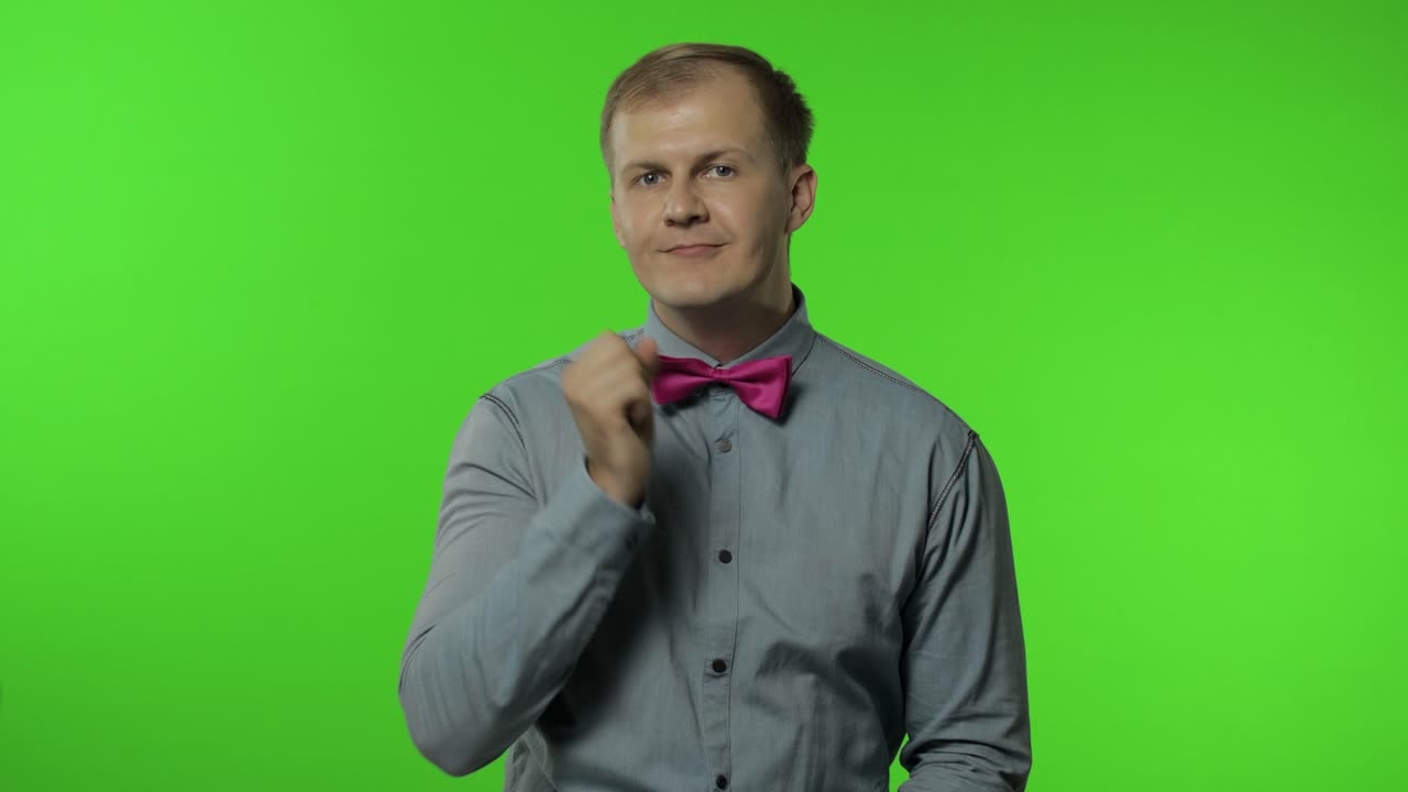 Guy putting finger on lips making silence gesture, asking to keep secret. Man portrait on chroma key