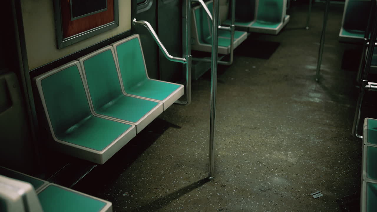 Empty subway train interior with teal seats and metal poles in the evening