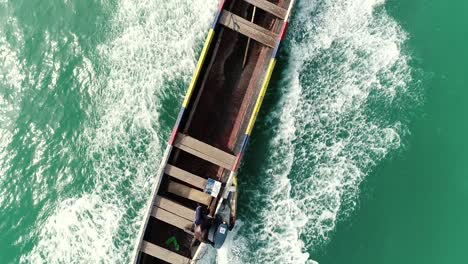 dron siguiendo una canoa en movimiento en el mar