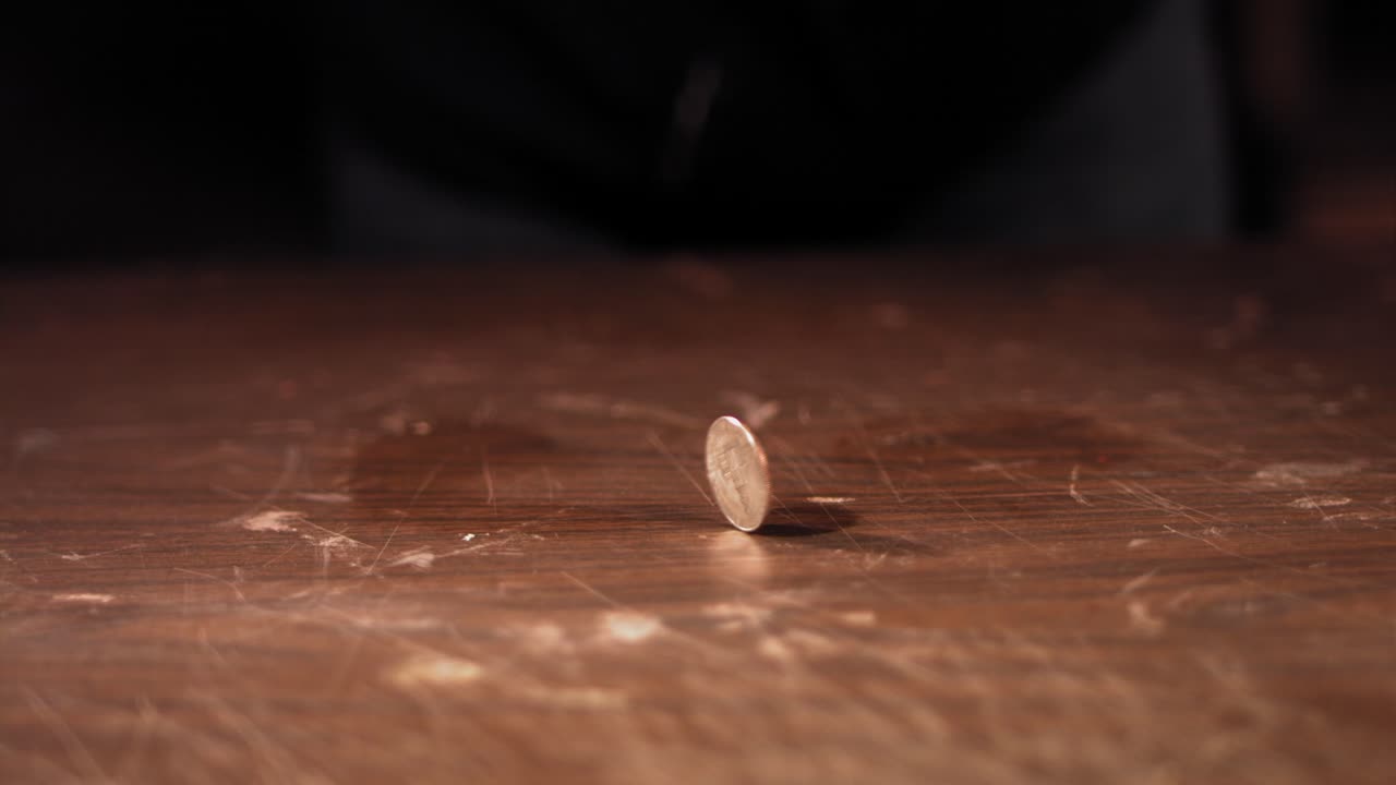 la mano hace girar una moneda dando vueltas en círculo