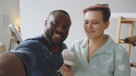 una pareja feliz tomando una selfie mientras pinta
