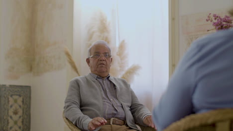 Front-view-of-senior-man-talking-with-wife-in-living-room