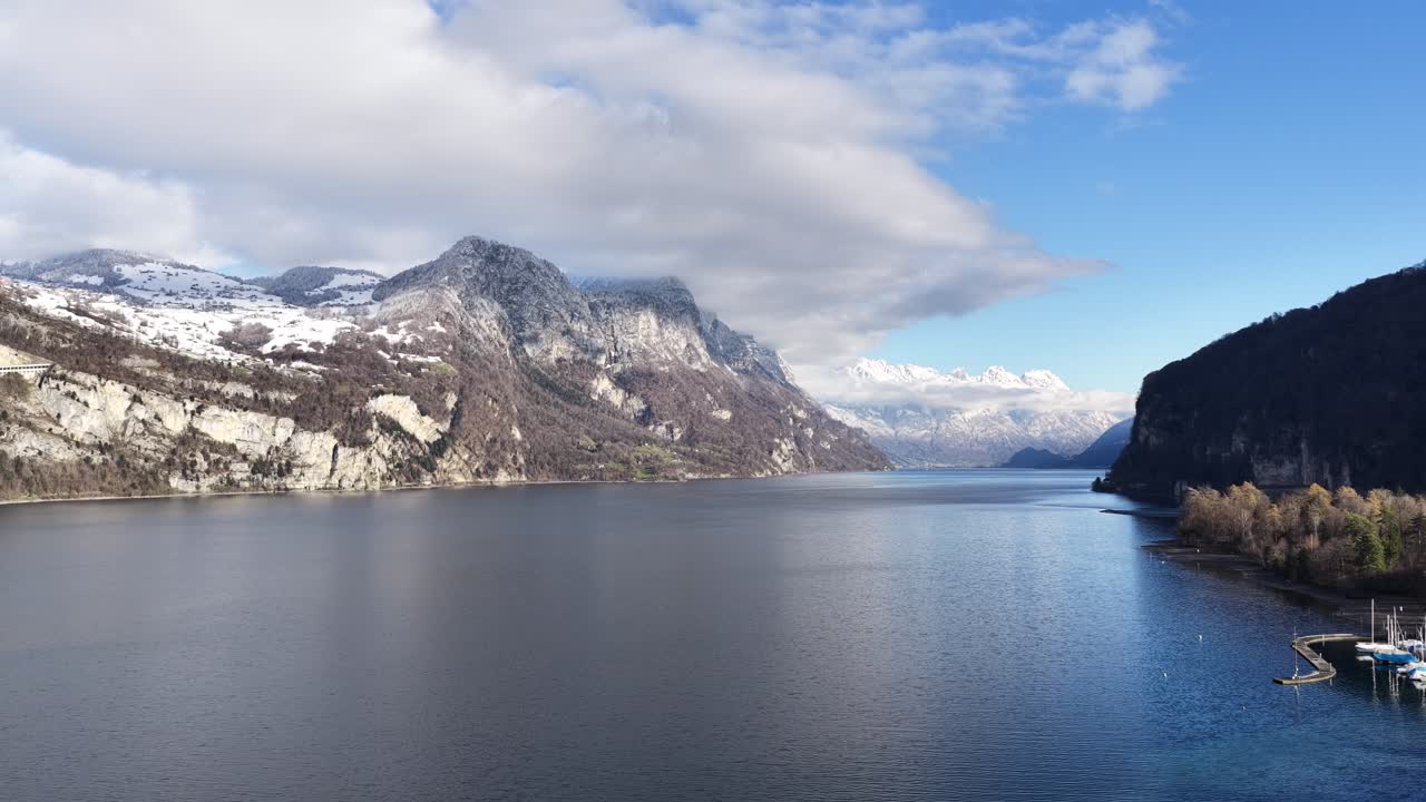 Aerial view of Lake Walensee with snowy mountains and calm blue water