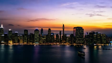 el horizonte de la ciudad de nueva york pasa lentamente de una brillante puesta de sol a una hermosa noche con luces de colores.