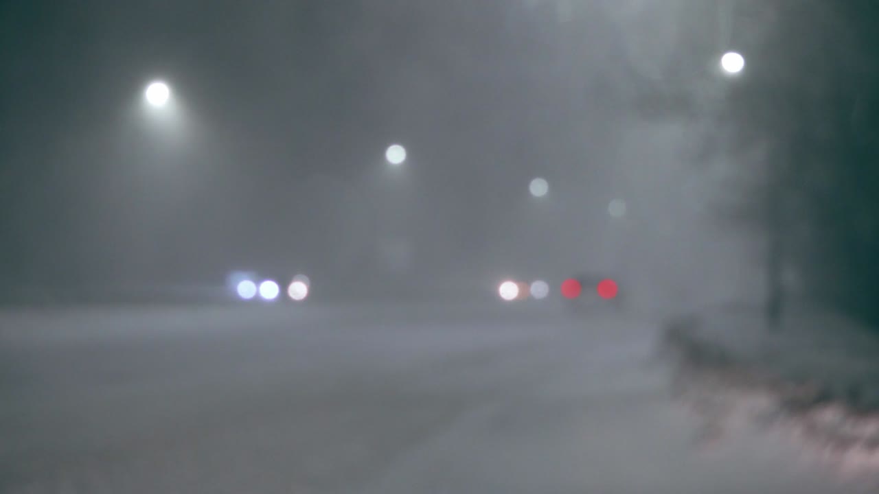 밤에는 도시 조명과 함께 흐릿한 도시 풍경, 흐릿한 배경, 도로에서 기계를 타고, 도시에서 눈이 내리고, 차 앞 유리 기기는 창문에서 눈을 청소합니다.