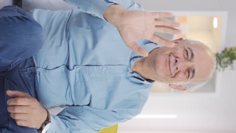 Vertical-video-of-The-old-man-waving-at-the-camera.