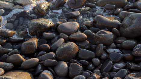 piedras en la playa con olas de mar salpicando