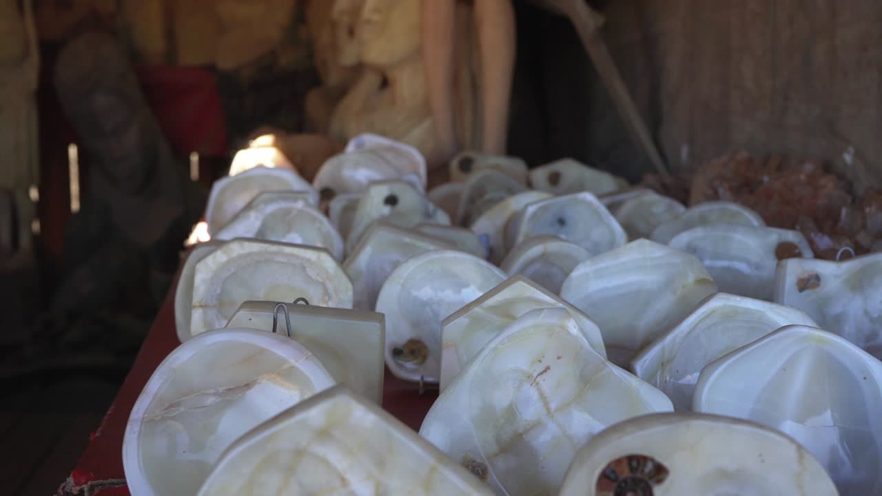 마다가스카르의 안타나나리보에 있는 기념품 시장에 전시되어 있는 작은 그이나 재통으로 형성된 암모나이트 화석이 있는 색 은 돌들