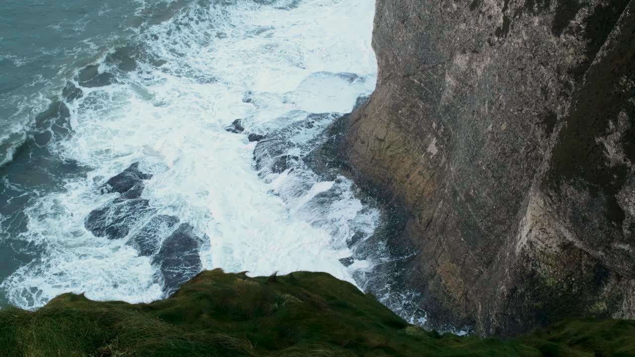 A tranquil yet dramatic coastal scene of waves breaking on rocks in slow motion