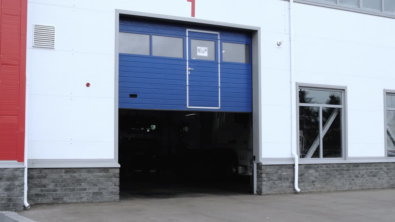 puerta rodante azul de la estación de servicio que se cierra de arriba hacia abajo