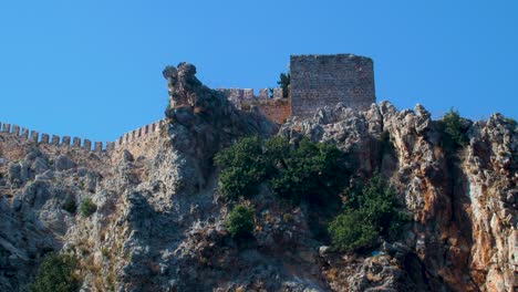 vista al mar de las ruinas de la antigua muralla de la fortaleza alanya en un día soleado de verano, cielo azul claro, toma de mano mediana