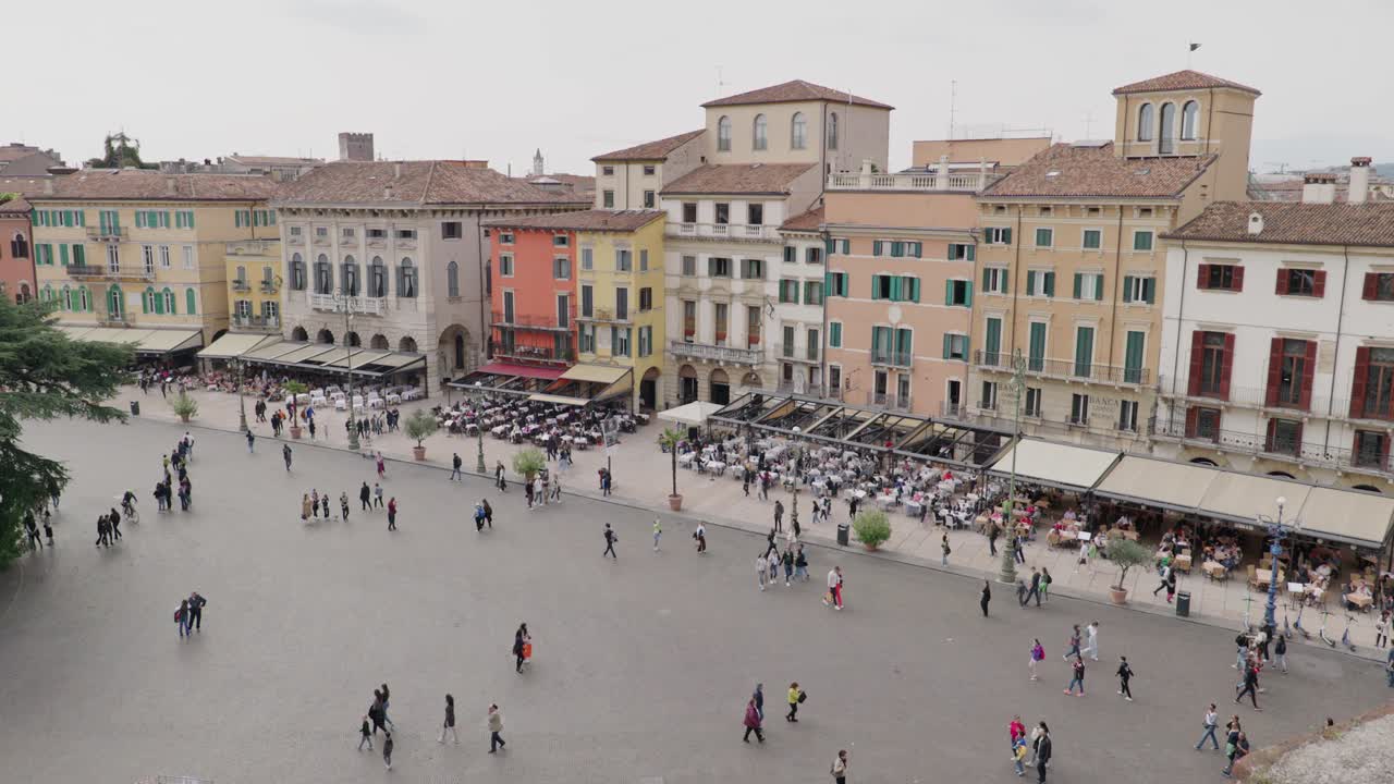 Residenti e turisti in Piazza Bra, circondati da caffè e ristoranti in Italia. - Panoramica.