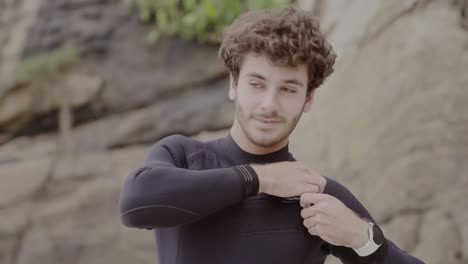 smiling young man in wetsuit outdoors