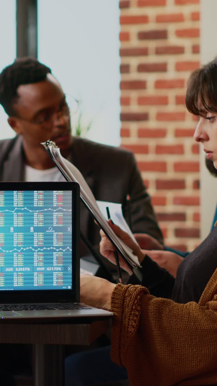Business team analyzing stock market data on a laptop