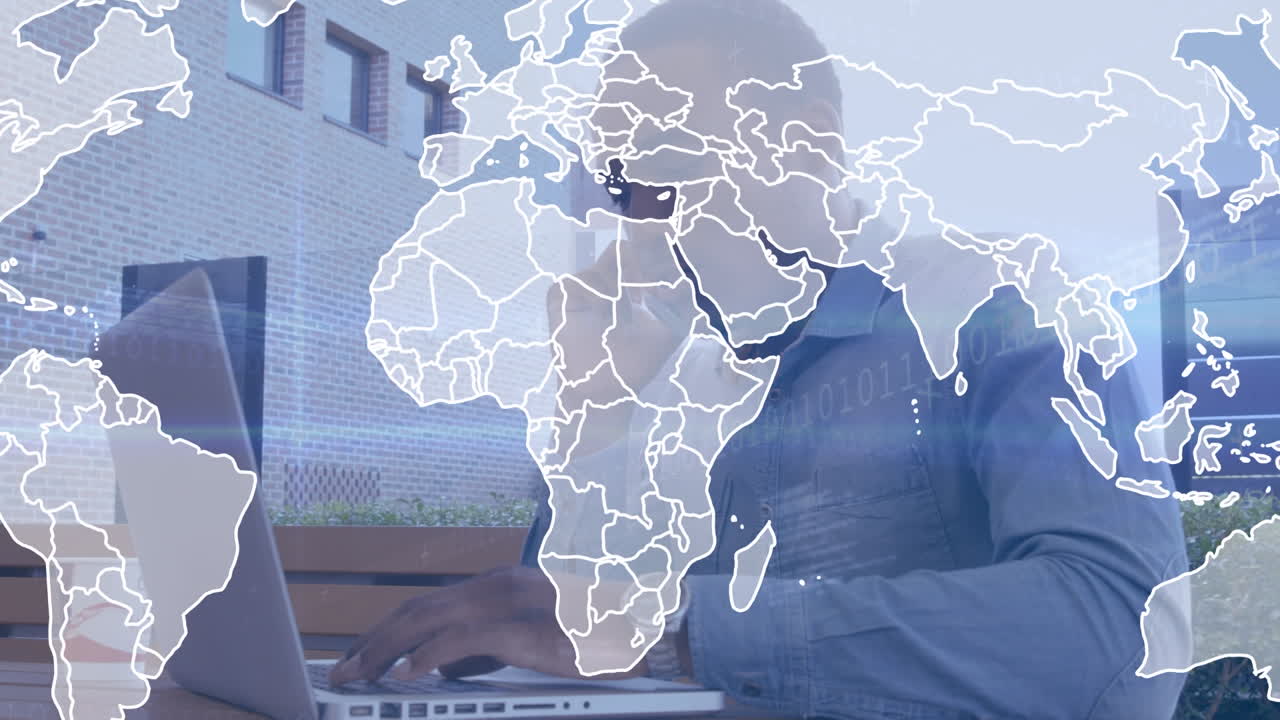 Animation of world map over african american businessman using laptop and talking on smartphone
