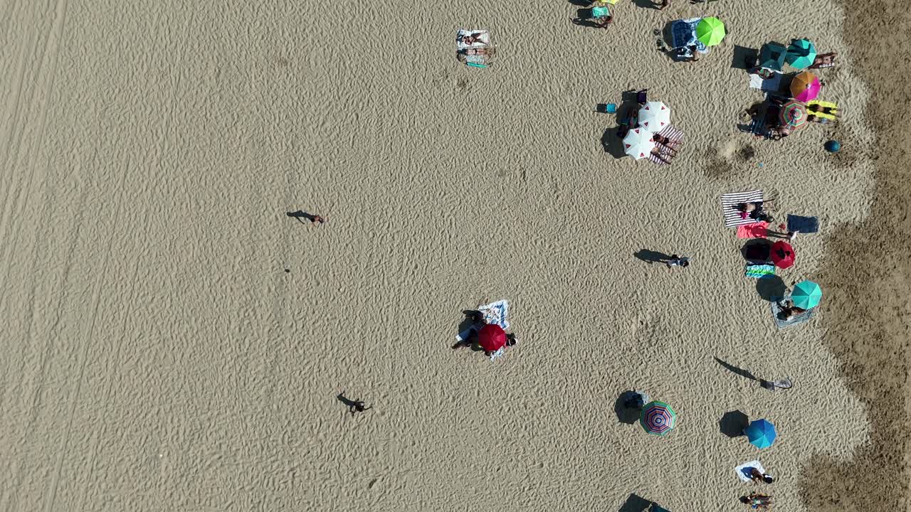 Aerial view of a beach with people and umbrellas