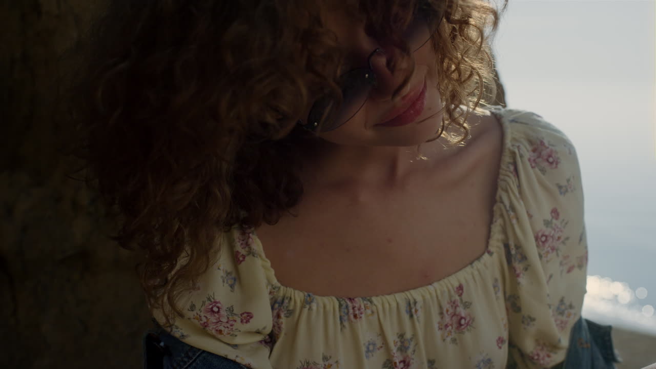 hermosa mujer sacudiendo el cabello rizado a la luz del sol de cerca. retrato de una chica feliz.