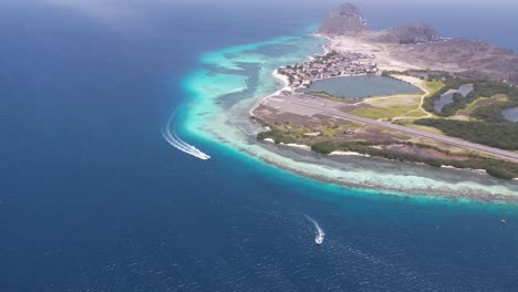 pan across tropical island with speed boats rushing around and tropical airpot runway down middle