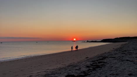 family taking a walk at amazing sunset on a solitary beach