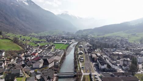 Foggy-day-with-cars-on-bridge-crossing-river-in-Glarus-City-in-winter