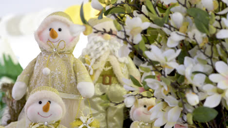 Süße-Schneemann-Familienpuppen-Und-Weihnachtsmann-In-Der-Nähe-Von-Blumen