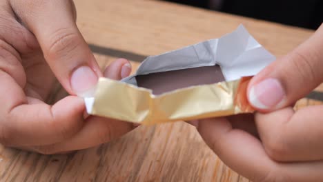 hands unwrapping a chocolate bar