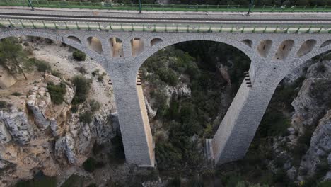 Luftaufnahme-Von-Einer-Drohne-Der-Großen-Brücke-über-Das-Tal,-Das-Sich-Zwischen-Den-Großen-Bergen-Gebildet-Hat