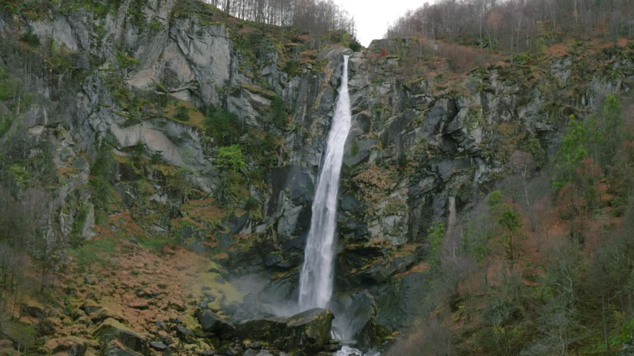 Una luminosa striscia di cascata illumina la roccia nera attraverso la quale l'acqua si fa strada.