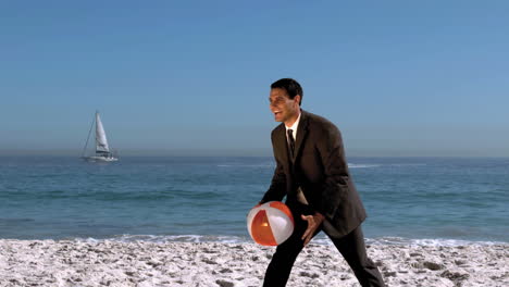 Attractive-businessman-playing-with-beachball