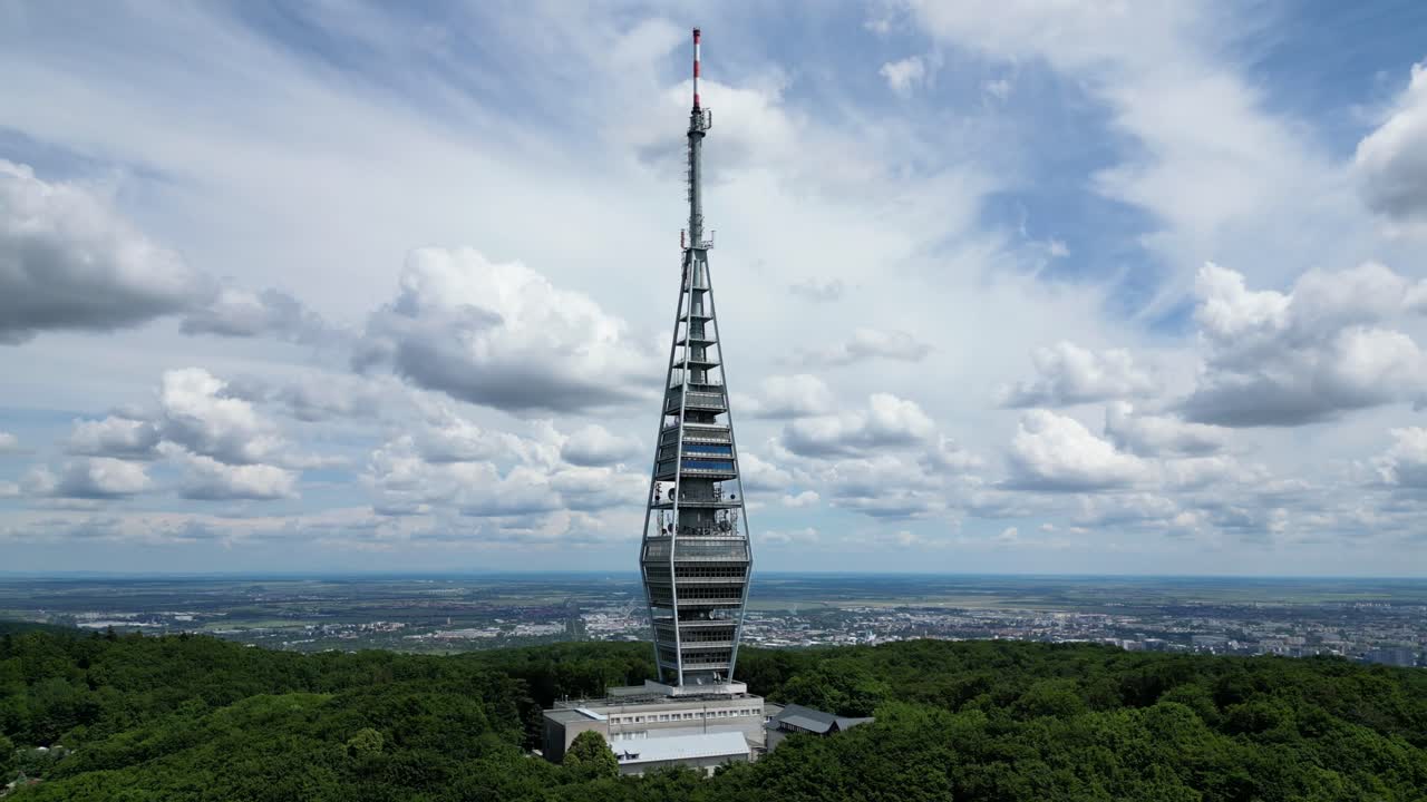 Aerial establishing shot of Kamzik TV Tower rising above the forest in Bratislava, Slovakia