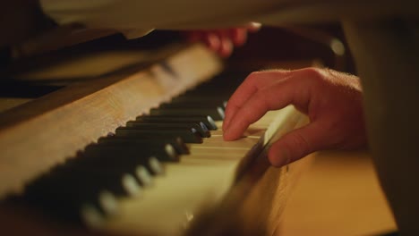 close up fingers playing the piano keys